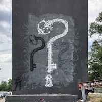 a black and white painting of a key on the side of a building