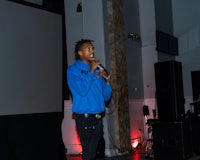 a man holding a microphone in front of a screen