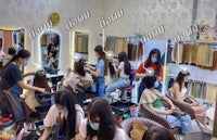 a group of women are getting their hair done in a salon