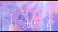 a man playing drums in front of a stage