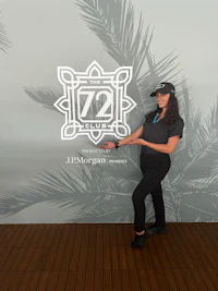 a woman standing in front of a wall with a palm tree logo