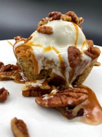 a dessert with ice cream and pecans on a plate