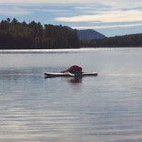 a woman on a paddle board in the middle of a lake