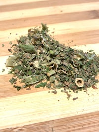 a pile of herbs on a wooden table