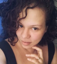 a woman with curly hair posing for a photo