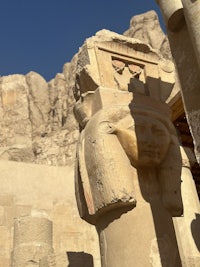 a statue of an egyptian head in front of pillars