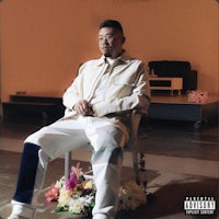 a man sitting on a chair in front of flowers