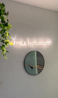a sign that says hey hot stuff on a wall