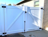 a white gate with a black handle on it