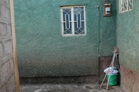 a green building with a door and window