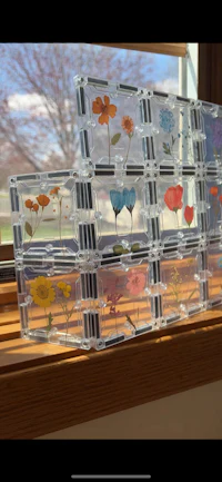 a set of clear flower boxes sitting on a window sill