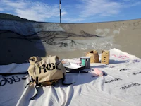 a backpack is sitting on a blanket with graffiti on it