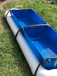 a blue and white plastic tub sitting on the grass
