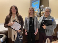 three women standing next to each other holding certificates