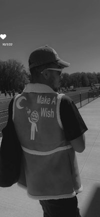 a man wearing a vest that says make a wish