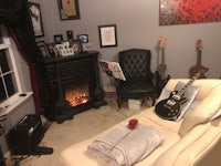 a living room with guitars and a fireplace