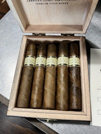 five cigars in a wooden box on a table