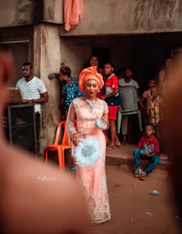 a woman in an orange dress standing in front of a crowd