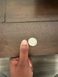 a person holding a coin on top of a table
