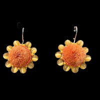 a pair of orange flower earrings on a black background