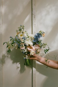 a woman is holding a bouquet of flowers