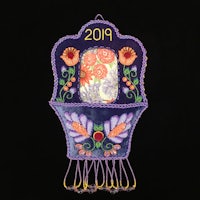 a purple hamsa hanging on a black background