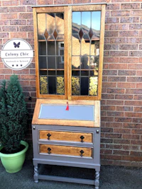 an old wooden desk with a glass top