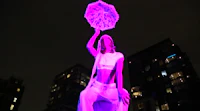a sculpture of a woman holding a purple umbrella