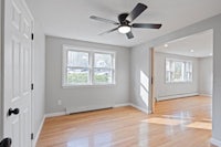 an empty room with hardwood floors and a ceiling fan