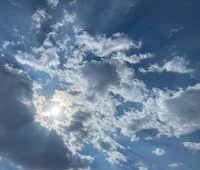 the sun shines through the clouds in a blue sky