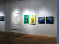 a group of paintings on display in an art gallery