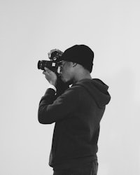 a black and white photo of a man holding a camera