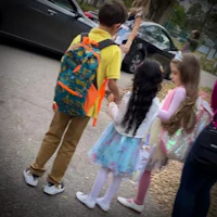 a group of children standing on a street with backpacks