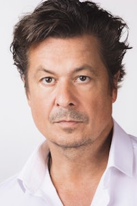 a man in a white shirt is posing for a photo