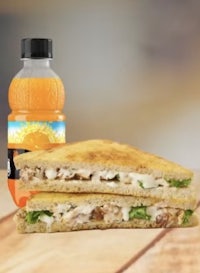 a sandwich and a bottle of orange juice on a table