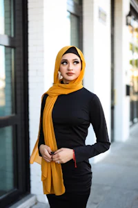 a woman wearing a yellow hijab and black dress