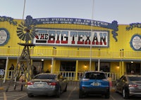 cars parked in front of the big texan