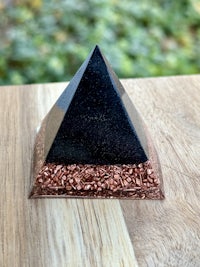 a black pyramid sitting on top of a wooden table