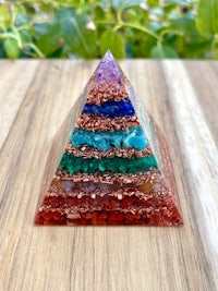 a pyramid made of colored stones on a wooden table