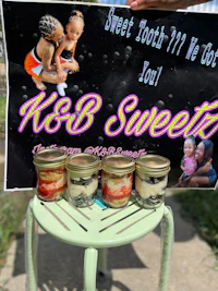 a woman holding up a sign that says k b sweet
