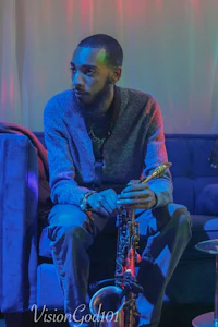 a man sitting on a couch with a saxophone