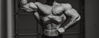 a black and white photo of a bodybuilder posing