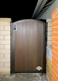 a wooden gate with a brick wall behind it
