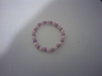 a pink and purple bead bracelet on a table