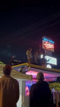 a group of people standing on top of a truck at night