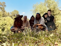 a group of people posing for a photo in the woods