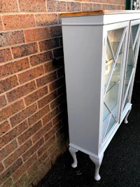a white curio cabinet with glass doors