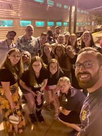 a group of people taking a selfie in front of a train
