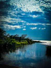a body of water under a cloudy sky