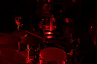 two people playing drums in a dark room